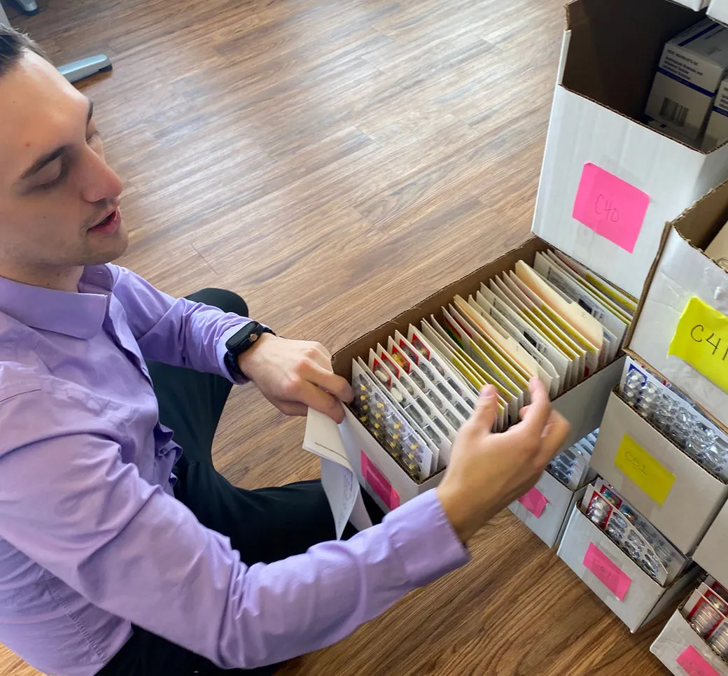 A pharmacy intern selecting inventory to fill an order
